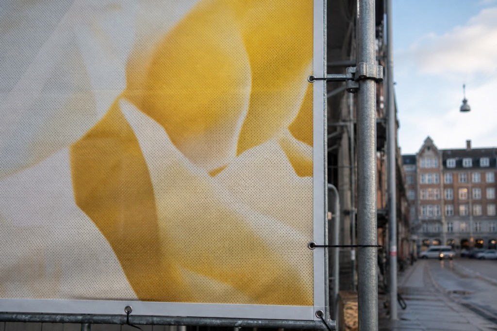 Mesh-banner på stillads med øjer og strips